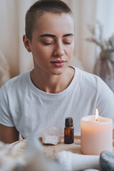 Young adult practicing mindfulness with essential oils nearby