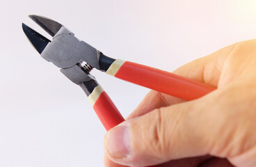 The hand holds the mounting tools to assemble the electrical switchboard. 