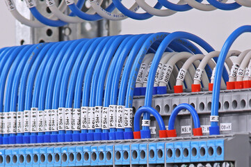 Electrical screw through terminals with connected insulated wires in an electrical switchboard.