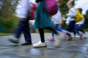 School children walking with female teacher, motion blur