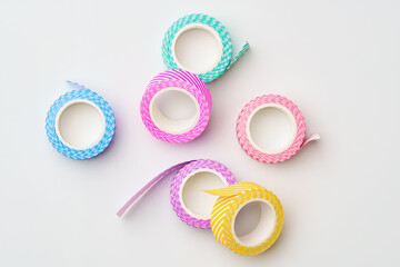 Colorful decorative tape rolls in pastel shades arranged on a light background for arts and crafts projects