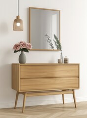 Light wooden dresser with two drawers, a rectangular mirror, a vase of pink flowers, and a minimalist pendant lamp against a white wall. Neutral