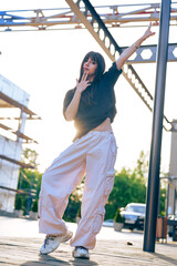 Fototapeta premium Dance performance at sunset in an urban setting with a stylish dancer in casual attire showcasing movement