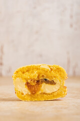 Macaron cake with tropical filling inside. Cross-section of the cake with chocolate, cream, mango and passion fruit ganache. The dessert is decorated with wafer crumbs and yellow chocolate.