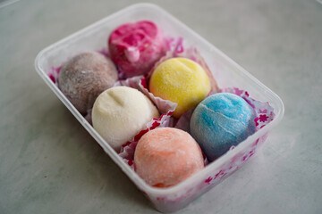 Six colorful mochi ice cream balls in a pink package. A delicious summer treat. Assorted Colorful Mochi Ice Creams in Pink Packaging