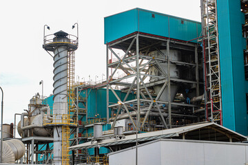 Large industrial power plant complex with tall smokestacks at dusk