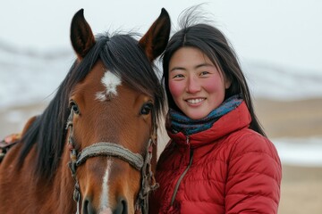 Obraz premium Young woman smiles beside a horse in a sunny barn setting during winter