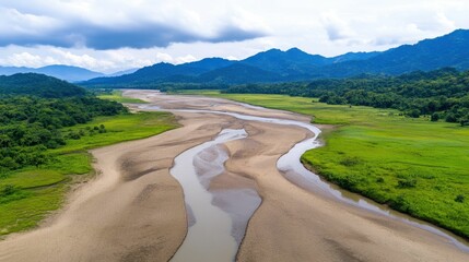 Cracked dry riverbed winding through a deforested region highlighting the consequences of disrupted ecosystems and the environmental impact of deforestation  The scene depicts a rural