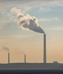 A large stack of smoke is rising from a power plant