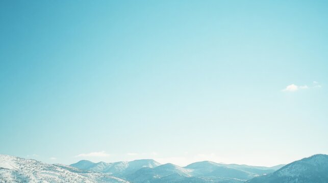 An expansive sky dominates the view, peeking over snowy mountain peaks, suggesting openness and endless possibilities.