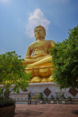 Low angle view of the big, tall and golden Buddha statue at the Wat Paknam (Pak Nam) Phasi Charoen Temple in Bangkok, Thailand on a sunny day.
