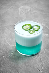A refreshing cocktail made with blue curacao and topped with a spicy jalapeno garnish