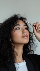 Obraz premium Portrait of a Young Woman Applying Makeup with a Brush