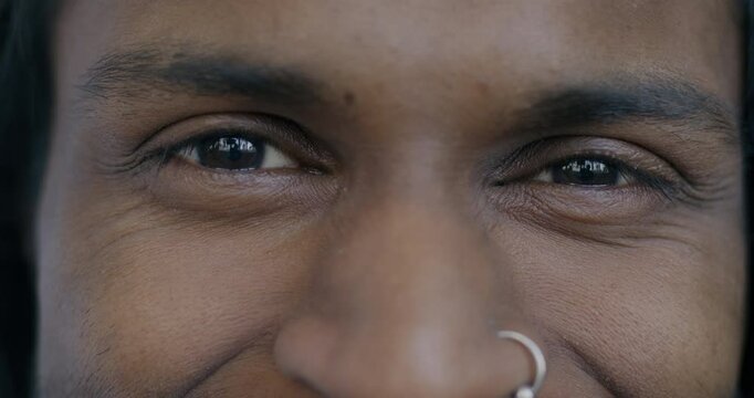 Close-up portrait of male eyes while happy Indian man looking at camera with joy. Positive emotion and human body part concept.