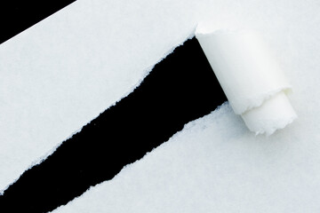 Torn of white paper scattered across a dark black background, offering a modern and abstract visual for design concepts.