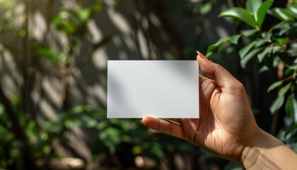 A hand holding a white card with no writing on it