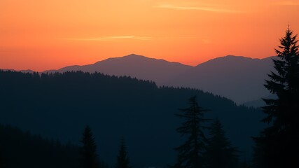 Obraz premium Majestic mountain range silhouetted against a vibrant orange sunset sky, showcasing layers of dark evergreen forests, creating a breathtaking natural landscape.