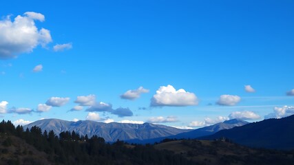 Fototapeta premium Serene landscape photography showcasing a picturesque mountain range under a vibrant blue sky adorned with fluffy white clouds.