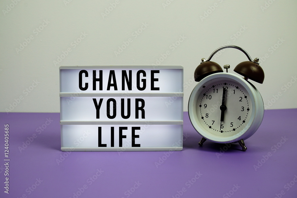 Poster change your life text on led lightbox with alarm clock on purple background
