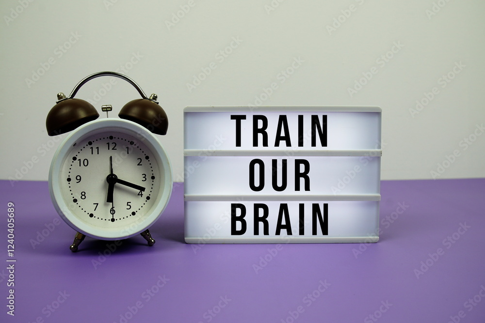 Poster train your brain text on led lightbox with alarm clock on purple background