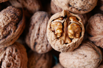 Fresh walnuts in their shells arranged on a wooden surface