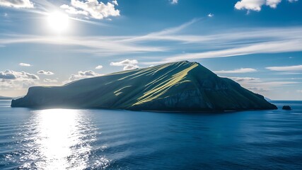 A sunlit verdant island mountain rises majestically from a calm ocean under a bright blue sky with fluffy white clouds, showcasing a breathtaking coastal landscape.