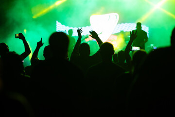 Crowd at concert and colorful stage lights.