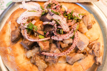 Delicious grilled meat on flatbread with fresh onions and herbs