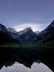 Magic photo of a lake reflecting the mountains during a hike in the Swiss Alps