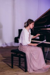 Elegant Woman in Evening Attire Practicing Piano in a Serene Setting