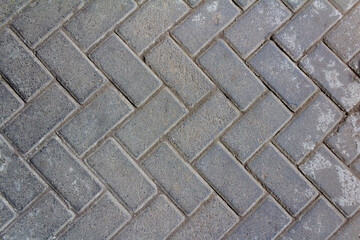 Interlocking Gray Paving Blocks in a Herringbone Pattern