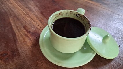 Side View of Traditional Javanese Black Coffee in Green Ceramic Cup with Saucer – Hot, Thick, Sweet Beverage with Sediment