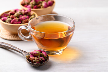 Rose tea in cup glass with dried rose bud on white background, Healthy flower tea