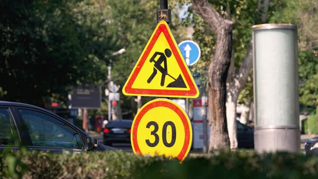 Construction activity slows traffic near busy intersection in city center. Traffic is limited to a speed of 30, while detours redirect vehicles around the area.
