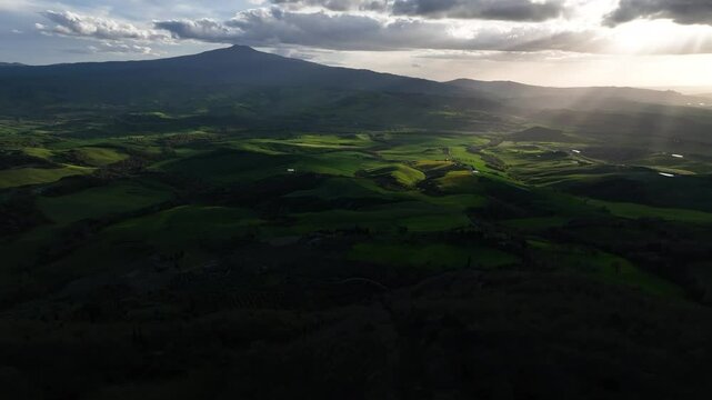 Vista con drone di un paesaggio rurale con raggi di sole che di taglio entrano in scena creando un effetto misterioso e solitario.