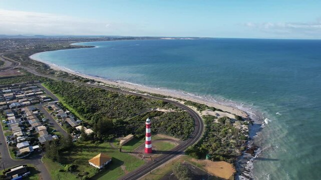 Aerial view of Point Moore Lighthouse and coastline with ocean waves, Cervantes, Australia.