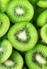 The image showcases a vibrant and fresh close-up of sliced kiwi fruits. The bright green flesh, tiny black seeds, and radial symmetry create a visually appealing pattern.