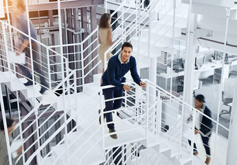 Man, creative and portrait with tablet on stairs of busy office for research and project as...