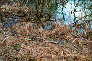 Various kinds of trash waste objects a lot floating in the pond mixed with aquatic plants