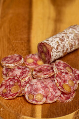 slices of fuet salami with walnuts on a wooden chopping board