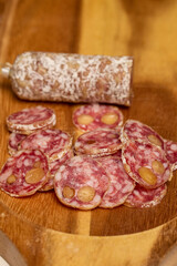 slices of fuet salami with walnuts on a wooden chopping board