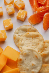 cheese, crackers, oranges on white plate