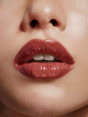 Naklejka premium Close-up of lips with cherry red brown lipstick or lip gloss
