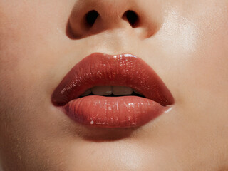 Naklejka premium Close-up of lips with cherry red brown lipstick or lip gloss