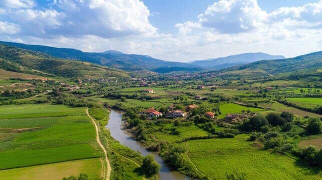 Scenic countryside landscape with river and rolling hills under a cloudy sky
