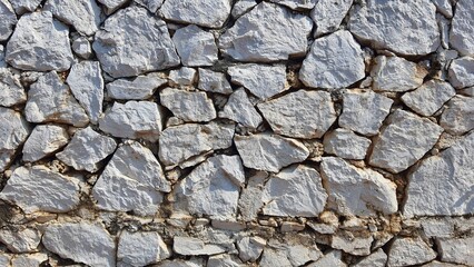 rock wall. Natural stone wall used as background or texture. Stone wall structure. Seaside stone wall texture background. Gray and brown stones mixed.