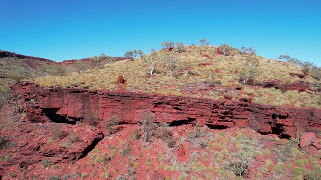 Aerial view of hamersley gorge with rugged hills and clear blue sky, karijini national park, pilbara region, australia.