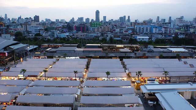 BANGKOK, THAILAND - AUGUST 2024 : View of &ldquo;The One Ratchada night market&rdquo; in sunset. High angle 4K time lapse shot, dusk to night.