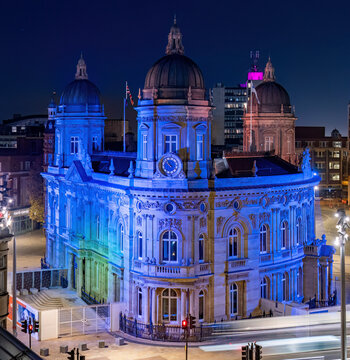 Aerial view of illuminated city hall and urban landscape at night with traffic and historic buildings, Hull, United Kingdom.