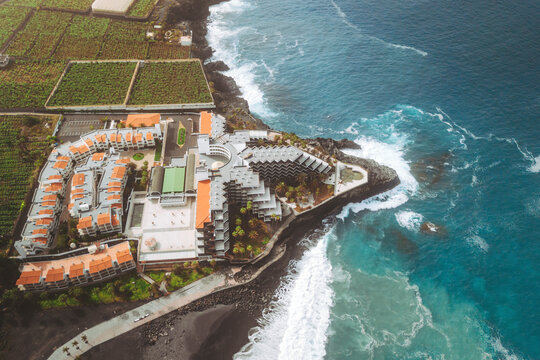 Aerial view of luxury resort overlooking beautiful coastline and ocean waves at Playa de Puerto Naos, Los Llanos de Aridane, Spain.